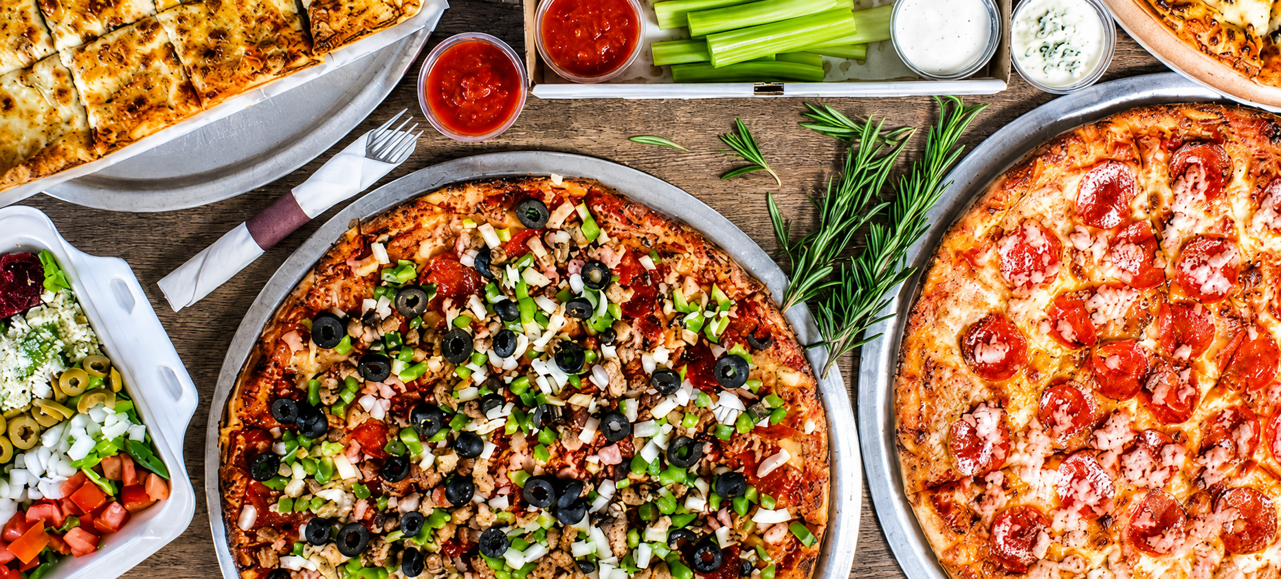 A table filled with pizza, salad and sides